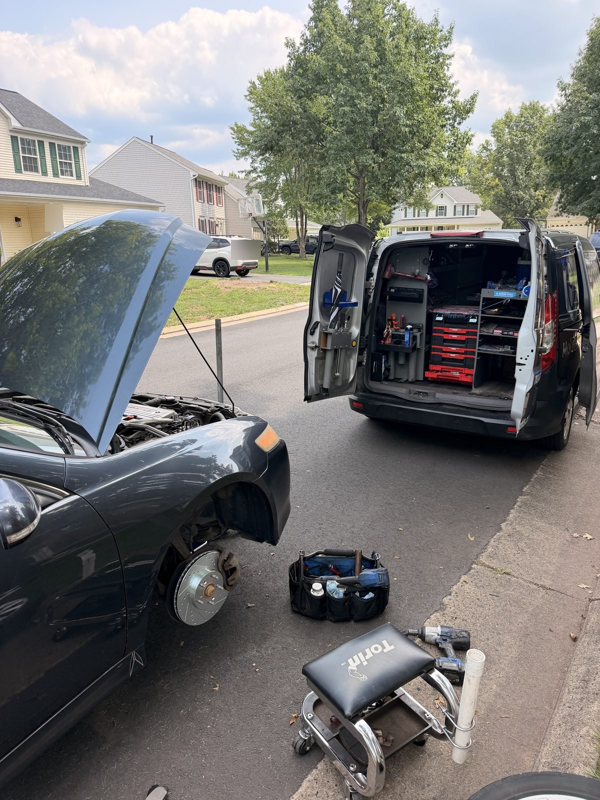 Brake Knights van open with tools laid out beside a customer's car during a brake job in an Ashburn driveway