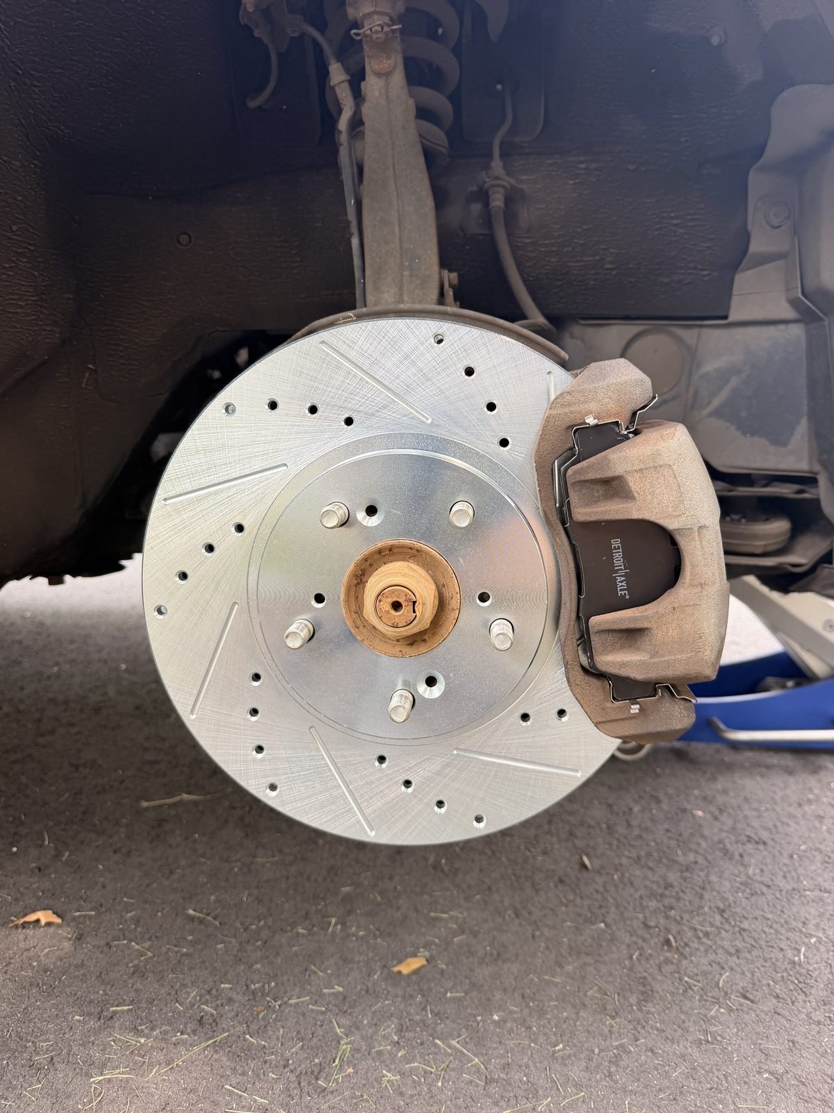 Newly installed drilled and slotted front brake rotor and pads on a customer's front hub in Ashburn